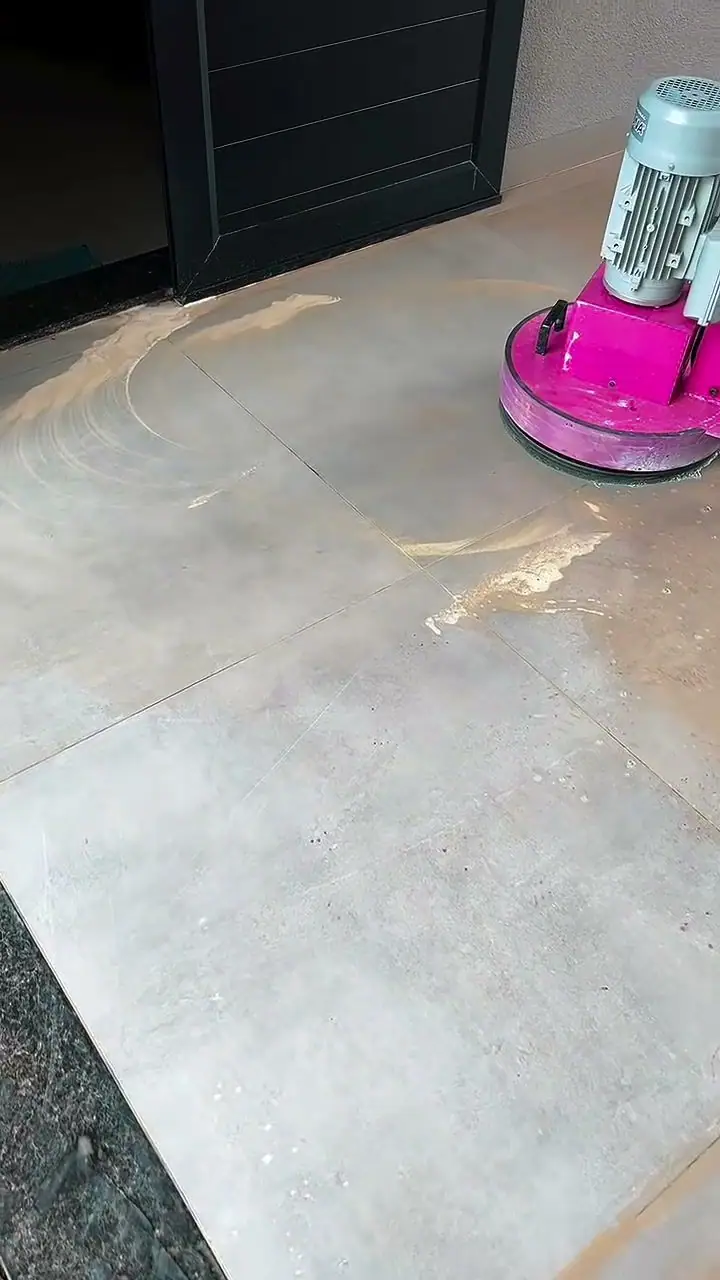 Enceradeira industrial rosa trabalhando sobre piso porcelanato