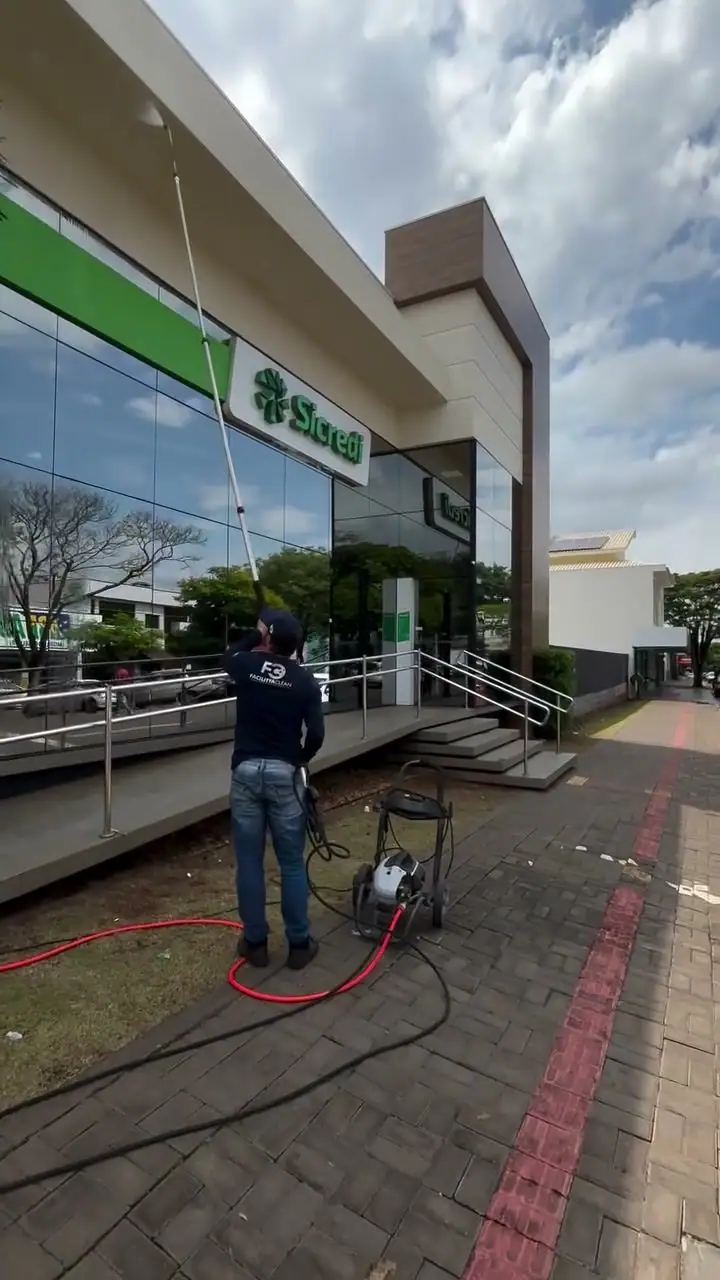 Lavadora de pressão sendo usada na fachada de uma agência